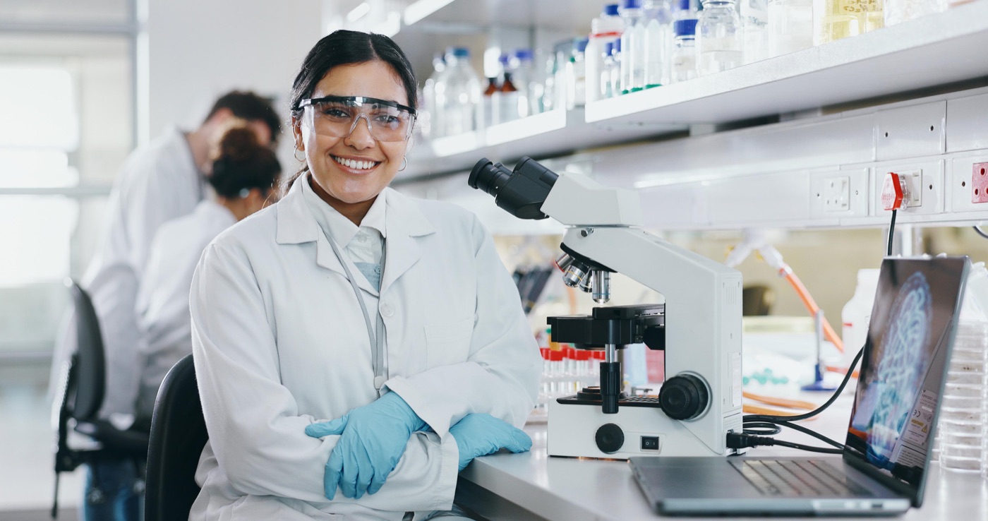 A smiling researcher at her microscope in a calcium research laboratory