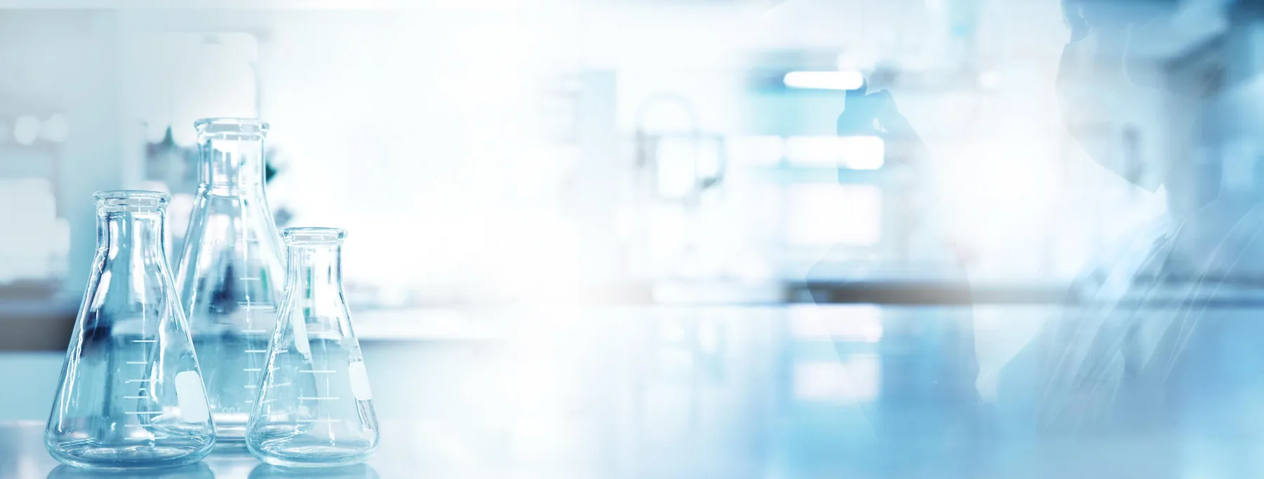 Laboratory glassware on a bench in soft blue light